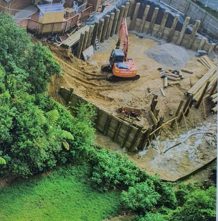 Excavator working on retaining and drainage groundworks