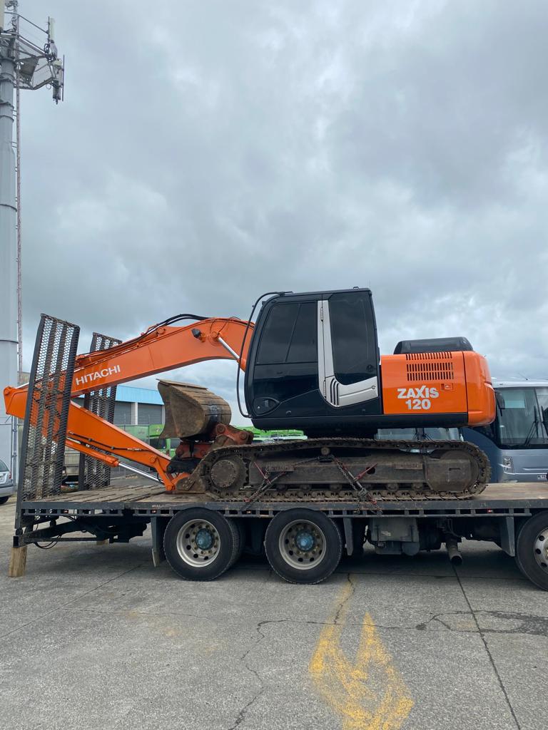 Excavator loaded onto a low loader transport truck