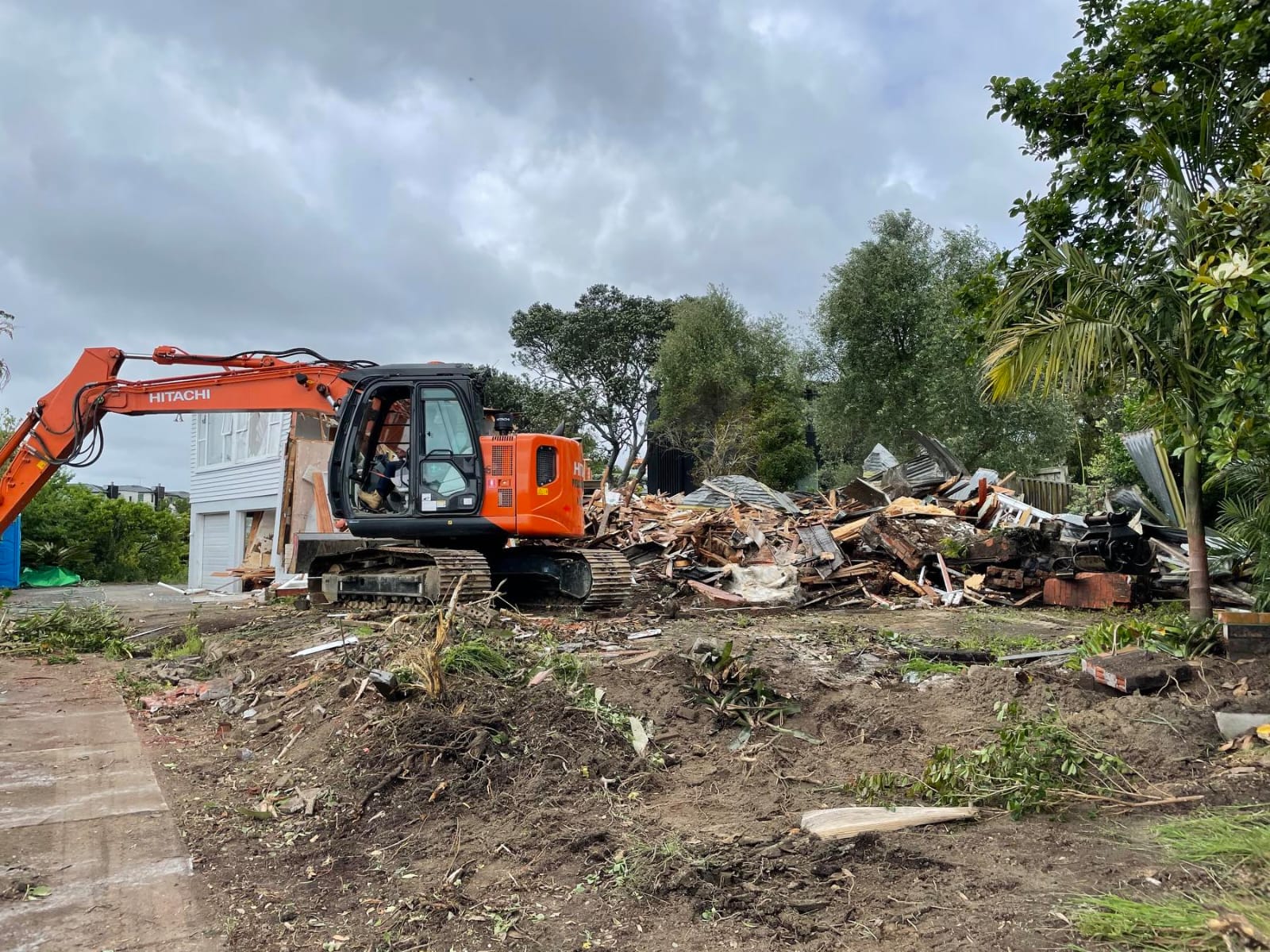 Excavator clearing demolition material